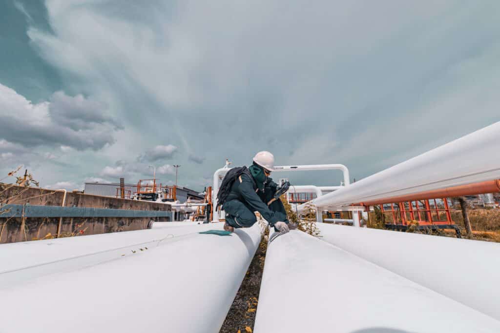 Worker inspects a pipeline for transporting oil and gas, Shutterstock ID#2489360977